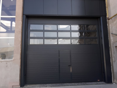 Ușă sectională industriala cu 3 panouri vitrate, usa pietonală cu maner antipanică, actionare electrică cu motor tifazic gama industrială.